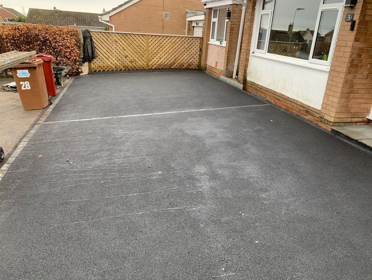 Wide asphalt driveway in front of a bungalow